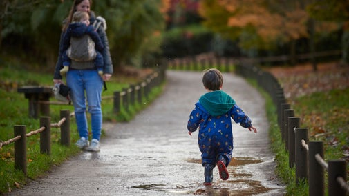 A child running along a path through puddles